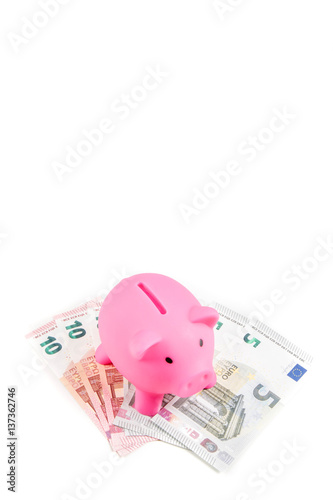 Piggybank standing on ten and five Euro banknotes