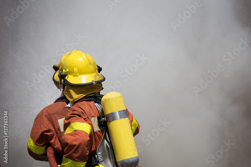 two firefighters fire fighting suround with dark smoke