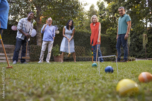 Obraz na płótnie Group Of Mature Friends Playing Croquet In Backyard Together