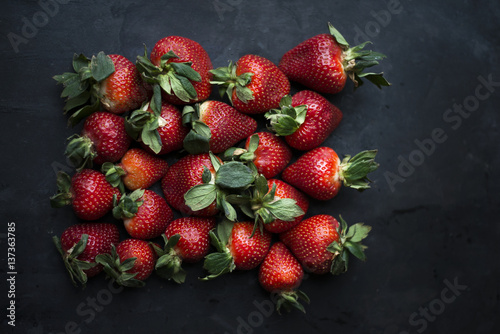 Overhead view of fresh strawberries on dark background