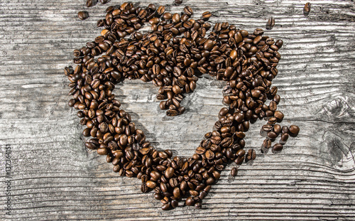 Coffee beans heart on old wood table