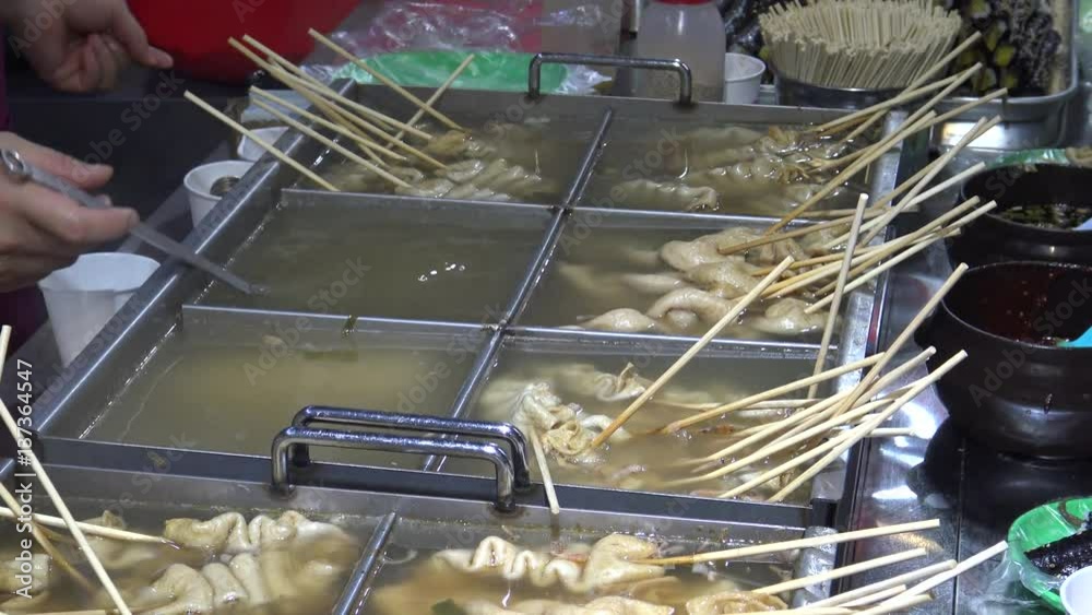 Korean Street Foods a variety of oden ingredients, people eating the fish cakes and other snack-Dan Korean Street Foods a variety of oden ingredients, people eating the fish cakes and other snack-Dan