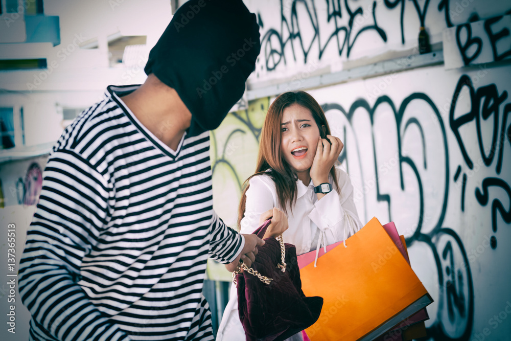 A thief stealing a black leather backpack (stealing) A thief stealing a black leather backpack (stealing)