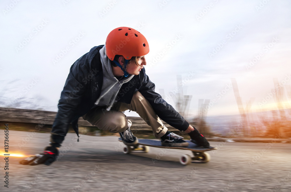Young man in is going to slide, slide with sparks on a longboard the asphalt Stock Photo | Adobe Stock