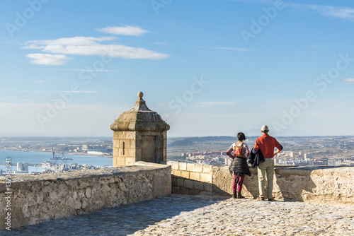 Tourists looking on Alicante city from the castle of Santa Barbara, Costa Blanca, Spain