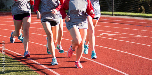 Group of girls training on a red track