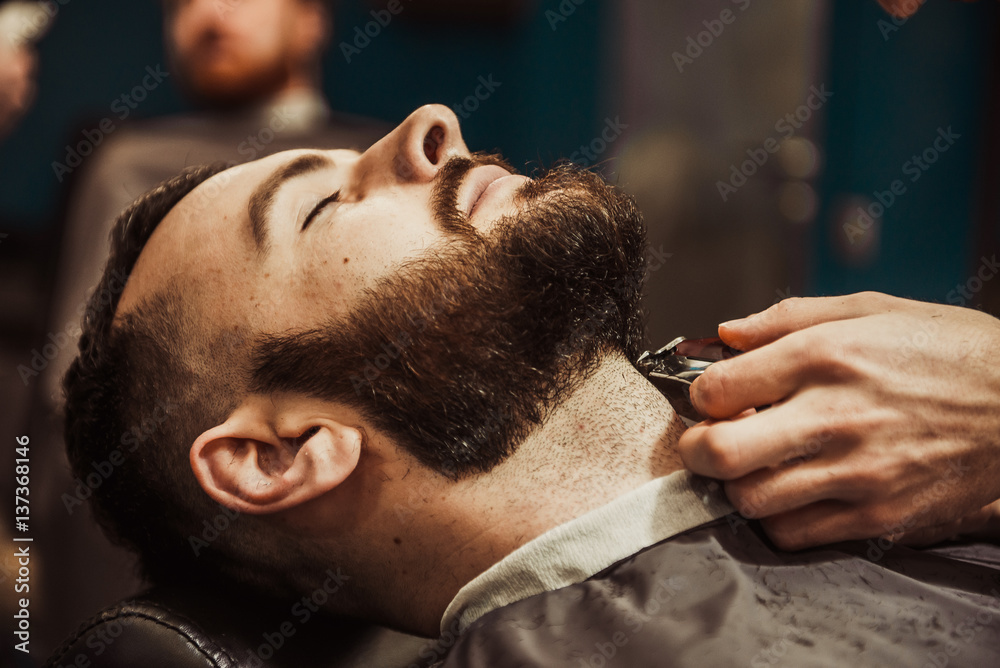 Fototapeta premium Professional Master hairdresser cuts client beard.