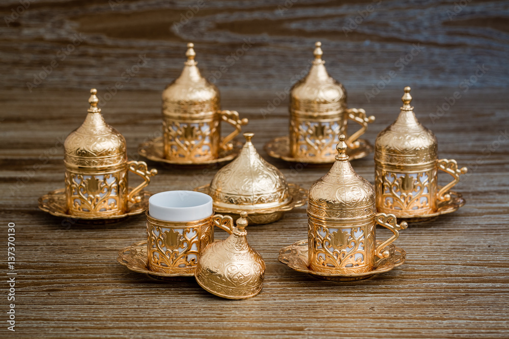 Traditional Golden Coffee Cup Set in a Tray on Wooden Background Traditional Golden Coffee Cup Set in a Tray on Wooden Background