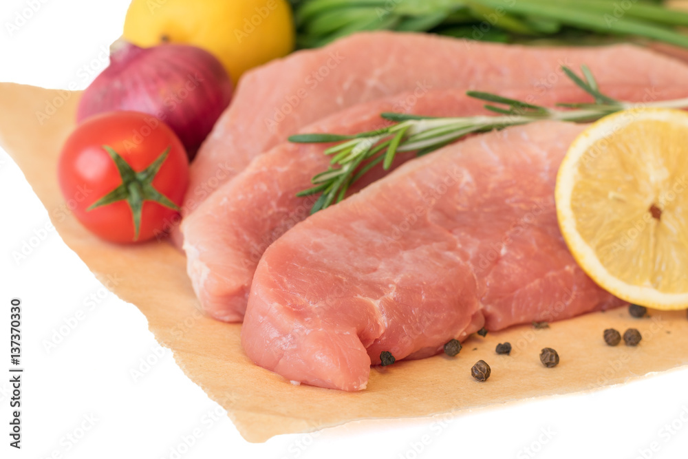 Sliced pork with vegetables and spices on paper. Sliced pork with vegetables and spices on paper.