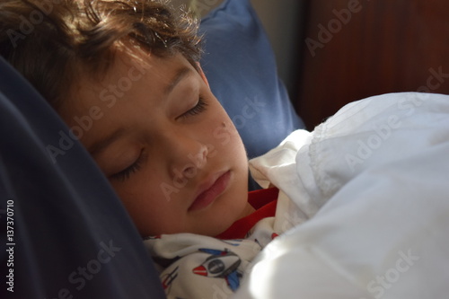 Foto Sick boy in bed with water bottle