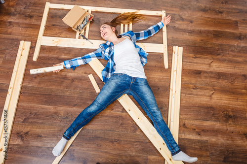 Happy woman having fun assembling furniture.