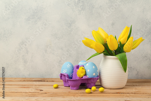 Easter holiday concept with tulip flowers and eggs decorationas on wooden table photo