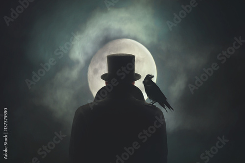 Man with crow on his shoulder observing the moon photo