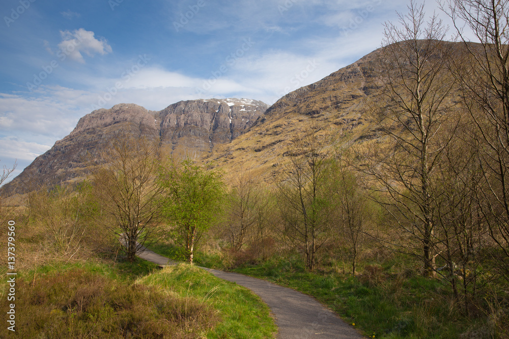 Pathway in Glencoe valley with snow topped mountains Scotland UK in Scottish Highlands in spring Pathway in Glencoe valley with snow topped mountains Scotland UK in Scottish Highlands in spring