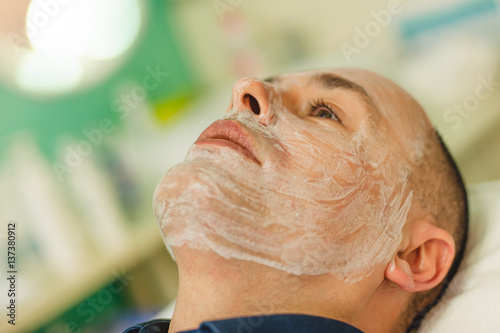 Relaxed man having a face massage and a peeling treatment