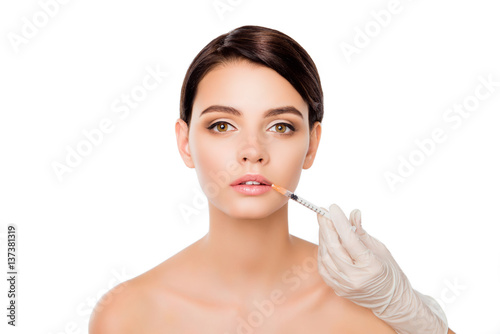 Young pretty woman geting cosmetic injection of botox in lips
