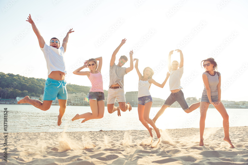 Group of happy young cheerful students jumping on the beach Group of happy young cheerful students jumping on the beach