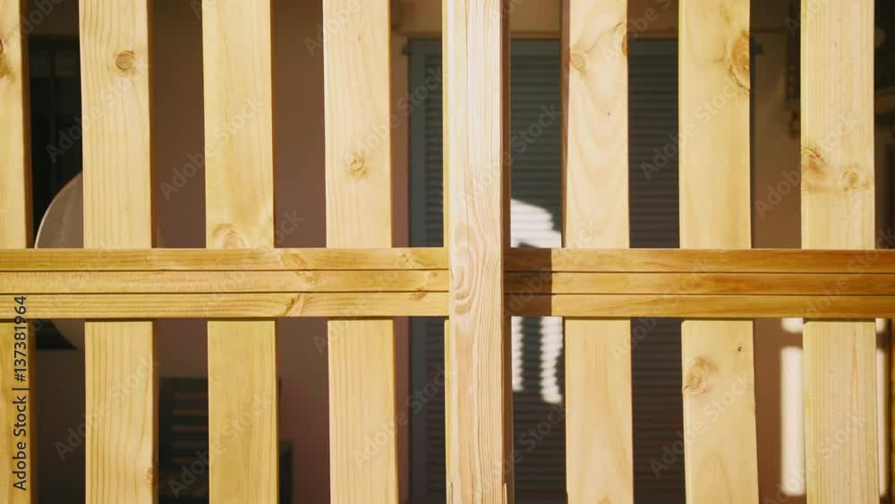 Camera moves on side in front of wooden fence protecting the entrance of private property in empty closed house at sunny day Camera moves on side in front of wooden fence protecting the entrance of private property in empty closed house at sunny day