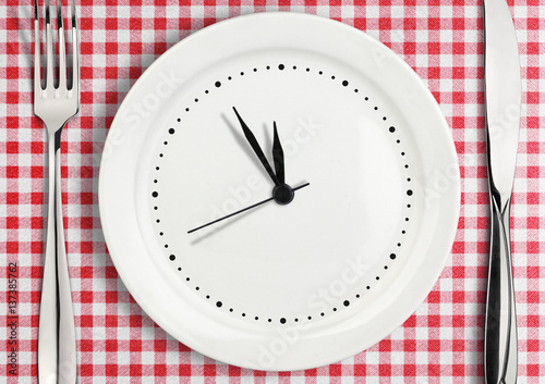 Table setting with blank clock on plate,  time concept