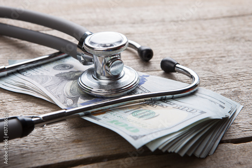 health insurance concept - stethoscope over the money photo