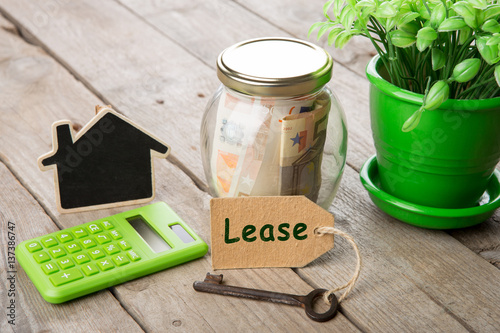 Real estate finance concept - money glass with Lease word