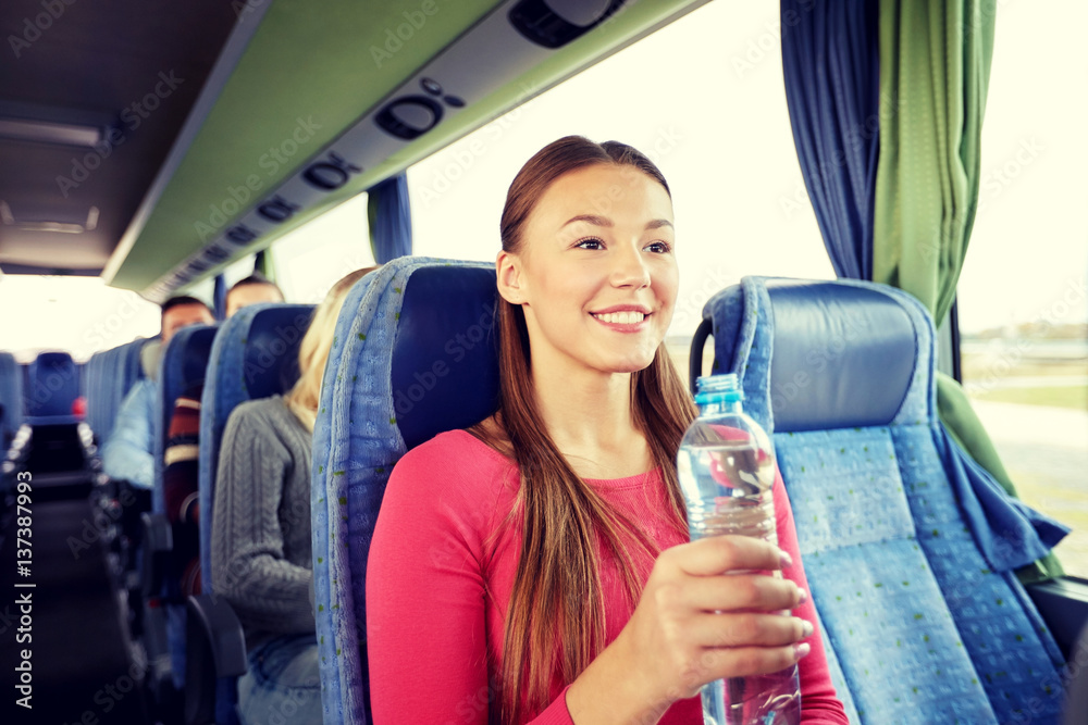 happy young woman with water bottle in travel bus happy young woman with water bottle in travel bus
