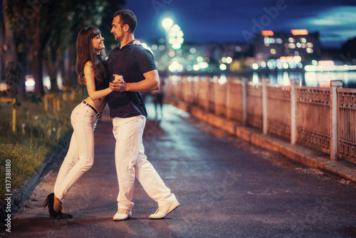 young couple dancing tango on the embankment