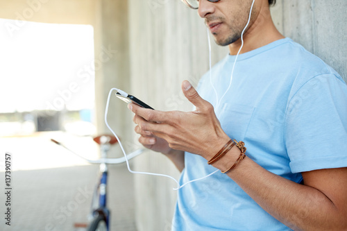 man with earphones and smartphone listening music