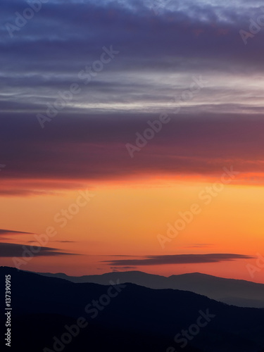 Sunrise in Slovakia. Orange sun sky over dark mountains. Romantic atmosphere. Fog hills at sunset. © matkovci