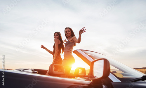 Young two women at a photo shoot. Girls gladly posing