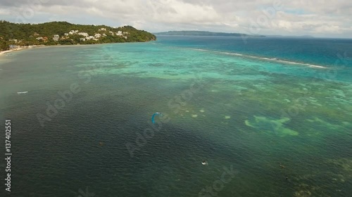 Kitesurfing on tropical island. Aerial view:kitesurfer sea rider rides at high speed through the waves. Kite surfing on a sunny day on a tropical island.Travel concept. Philippines, Boracay. 4K video