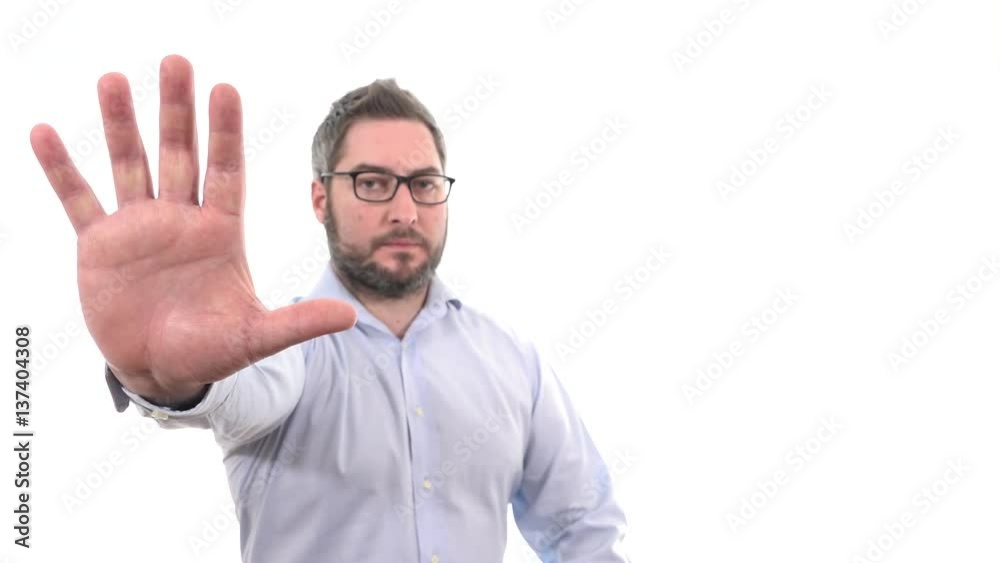 Serious man rising hand showing stop expression indoor white background medium close up, soft focused businessman Serious man rising hand showing stop expression indoor white background medium close up, soft focused businessman