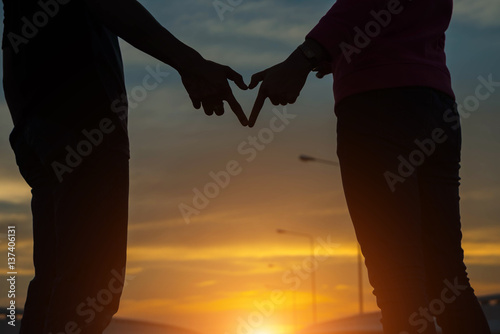 silhouette of couple in love.Focus on hands at sunset.