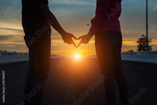 silhouette of couple in love.Focus on hands at sunset.