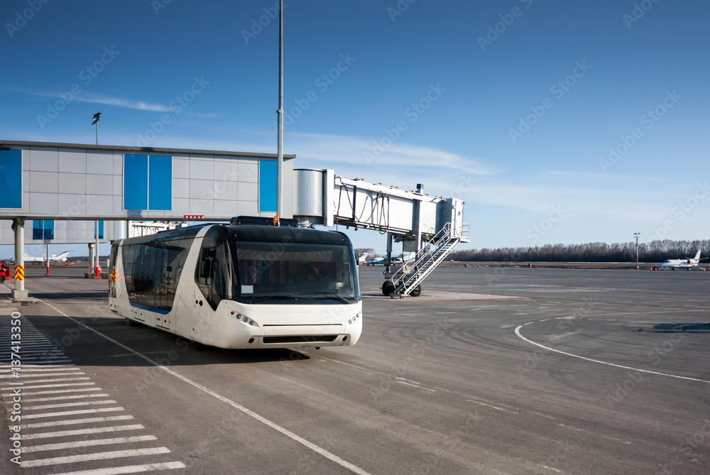 Bus at the airport apron near passenger boarding bridge Bus at the airport apron near passenger boarding bridge