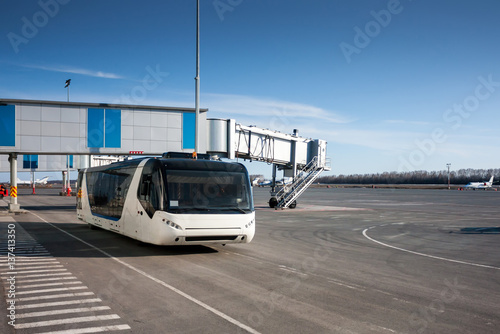 Bus at the airport apron near passenger boarding bridge