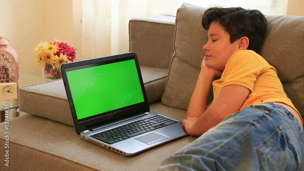 Child presenting a advertise with green screen laptop monitor Child presenting a advertise with green screen laptop monitor