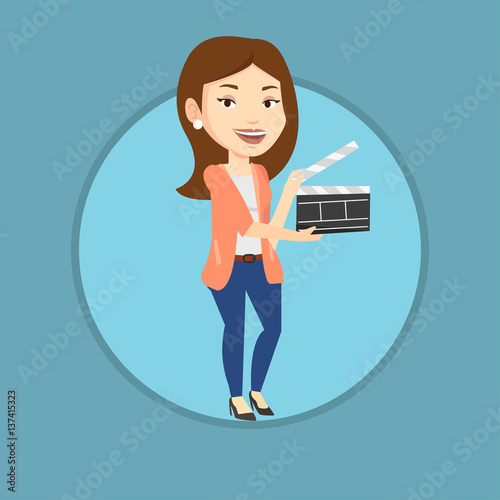 Smiling woman holding an open clapperboard.