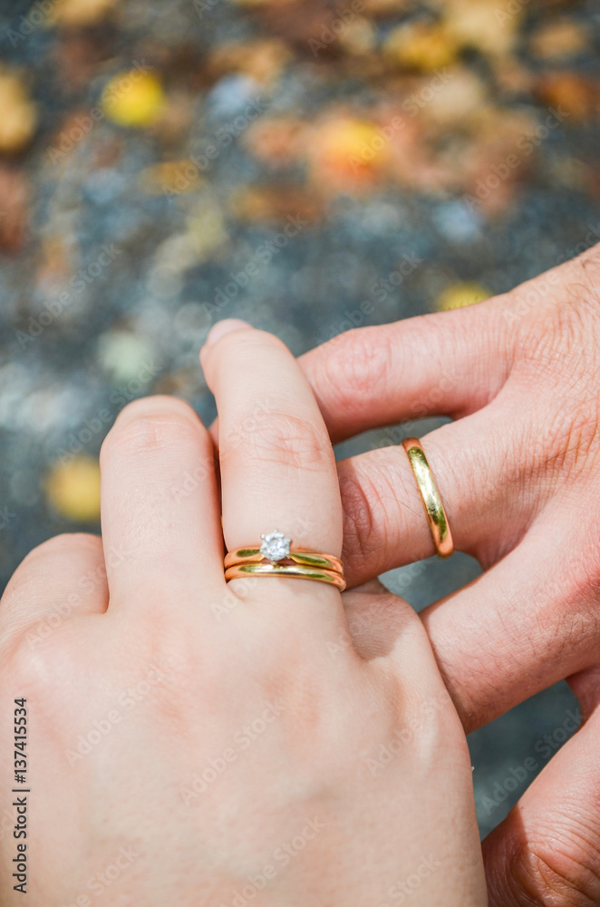 Husband and wife hands with marriage wedding rings on fingers