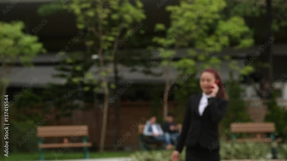 Smartphone girl using app on phone walking and talking smiling in the park. Beautiful multicultural young female professional on mobile phone. Asian model-Dan Smartphone girl using app on phone walking and talking smiling in the park. Beautiful multicultural young female professional on mobile phone. Asian model-Dan