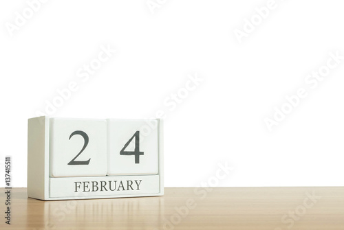 Closeup surface white wooden calendar with black 24 february word on blurred brown wood desk isolated on white background with copy space , selective focus at the calendar