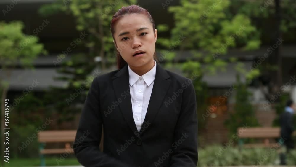 A asian business woman furious and upset in the park, displeased while looking at the camera with an angry expression. This clip can be used for many concepts related to anger and frustration-Dan A asian business woman furious and upset in the park, displeased while looking at the camera with an angry expression. This clip can be used for many concepts related to anger and frustration-Dan