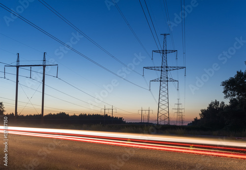 High voltage electricity pylon system and tracks from traffic.