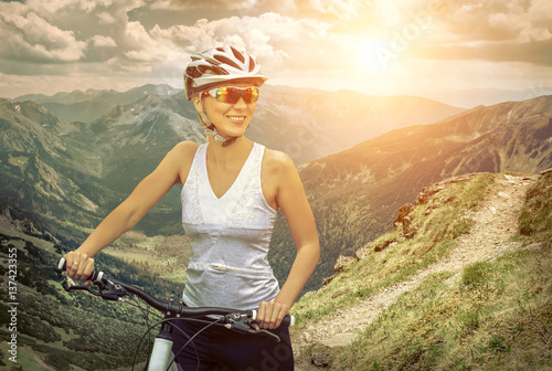 Beautiful woman in helmet and glasses stay on the bicycle around