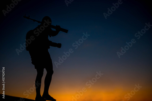 silhouette of a photographer who shoots a sunset.