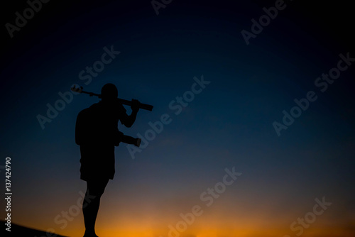 silhouette of a photographer who shoots a sunset.