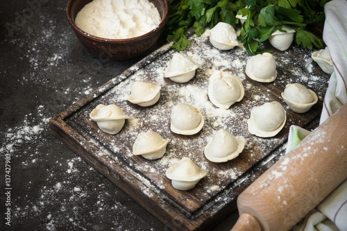 Traditional homemade pelmeni or dumpling at cutting board.