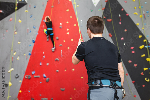Εκτύπωση καμβά Coach climber belay amateur athlete on a high climbing wall.