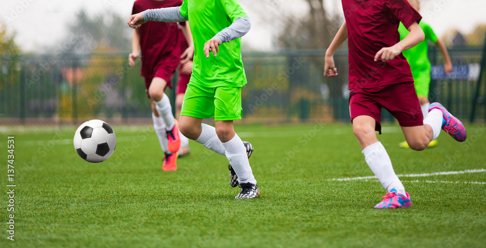 Football Soccer Match for Children. Kids Playing Soccer Game Tournament. Boys Running and Kicking Football on the Sports Grass Field Football Soccer Match for Children. Kids Playing Soccer Game Tournament. Boys Running and Kicking Football on the Sports Grass Field
