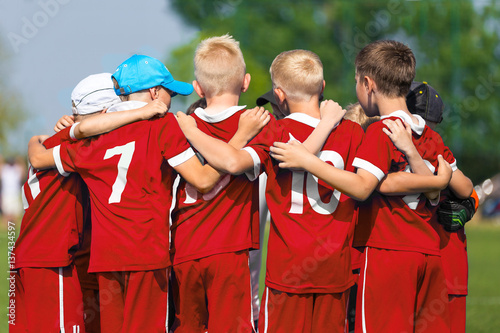 Children Soccer Team. Children Football Academy. Kids Soccer Players in Red Shirts Standing Together on the Pitch. Youth Soccer Motivational Speech. Coach Motivational Talk With Young Boys
